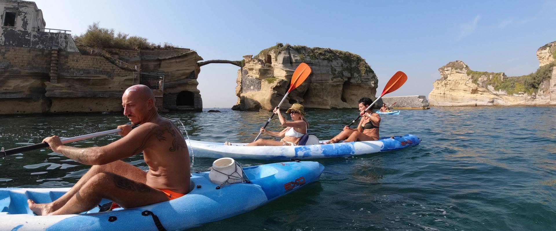 Tre persone in kayak attraversano l'aria marina protetta di Gaiola